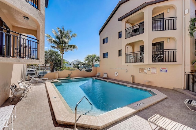 pool with a patio and fence