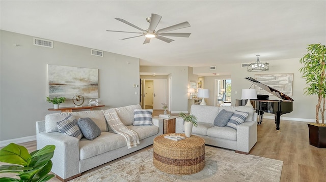 living room with visible vents, light wood-style flooring, and baseboards