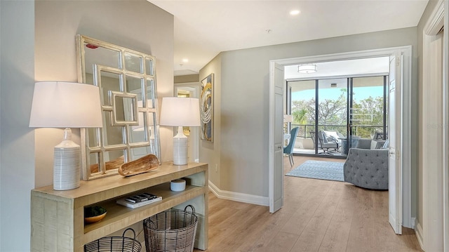 hallway with light wood-type flooring and baseboards