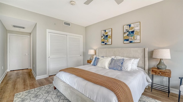 bedroom featuring a closet, visible vents, baseboards, and wood finished floors