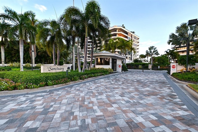 exterior space with curbs, a gated entry, traffic signs, and a gate