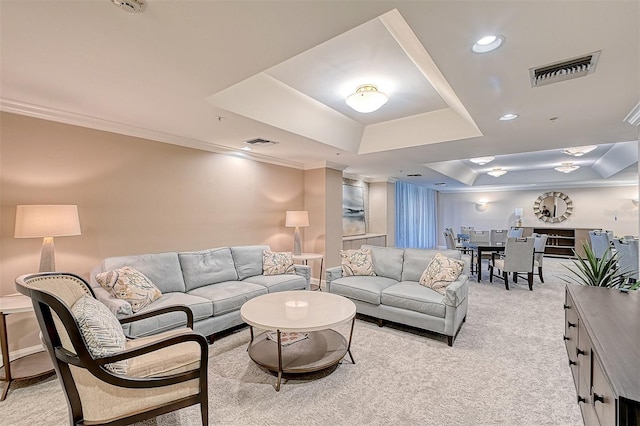 living area featuring light colored carpet, a tray ceiling, visible vents, and crown molding