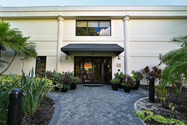 property entrance featuring french doors and stucco siding