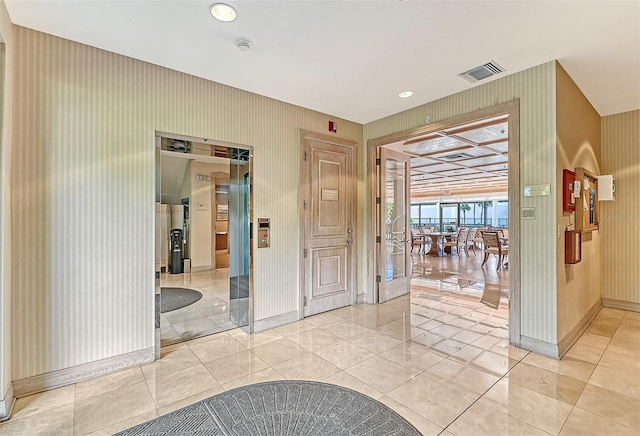 interior space with wallpapered walls, baseboards, light tile patterned floors, and visible vents