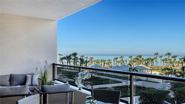 balcony with a water view and an outdoor living space