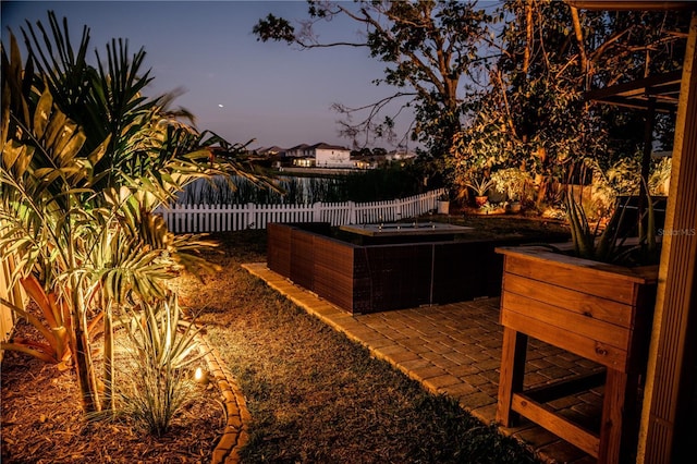 yard at dusk featuring a fenced backyard and a patio