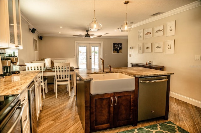 kitchen featuring french doors, crown molding, light wood-style flooring, appliances with stainless steel finishes, and a sink