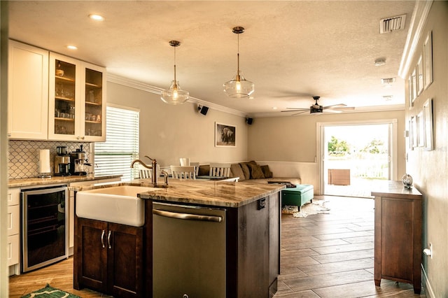 kitchen with visible vents, dishwasher, wine cooler, wood finished floors, and a sink