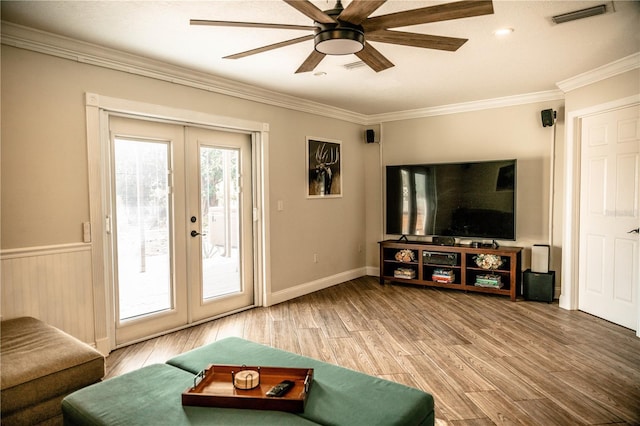 living room with french doors, crown molding, light wood finished floors, visible vents, and ceiling fan