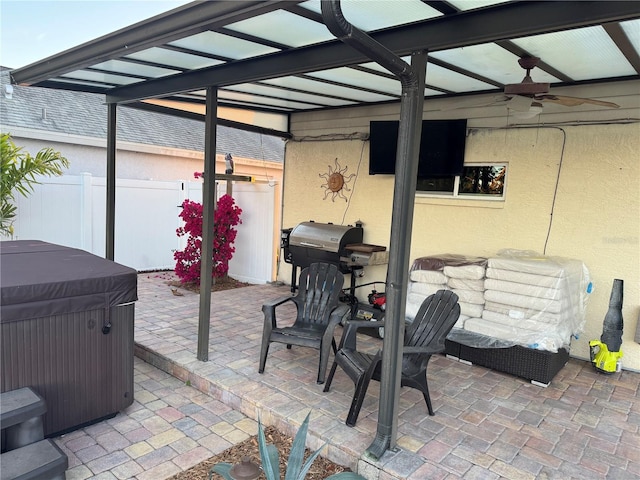 view of patio featuring a hot tub, fence, and grilling area