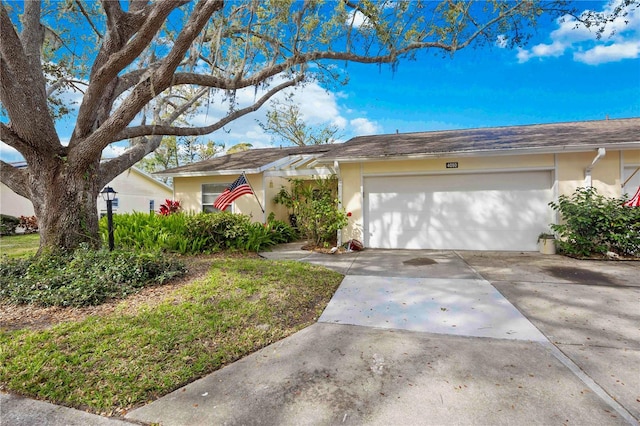 single story home featuring an attached garage, driveway, and stucco siding