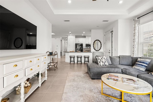 tiled living room featuring a raised ceiling