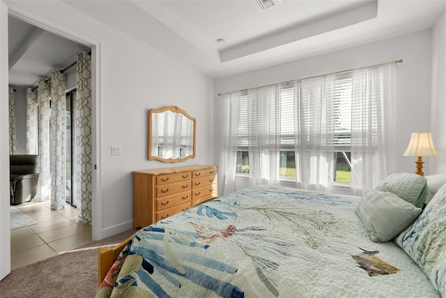bedroom with light tile patterned flooring and a tray ceiling