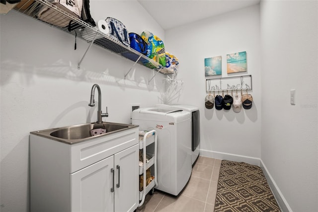 laundry area featuring sink, cabinets, washing machine and dryer, and light tile patterned floors