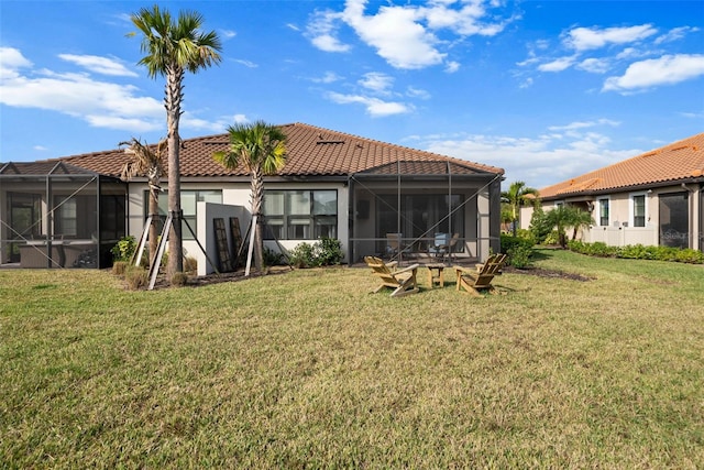 rear view of property featuring a yard and glass enclosure
