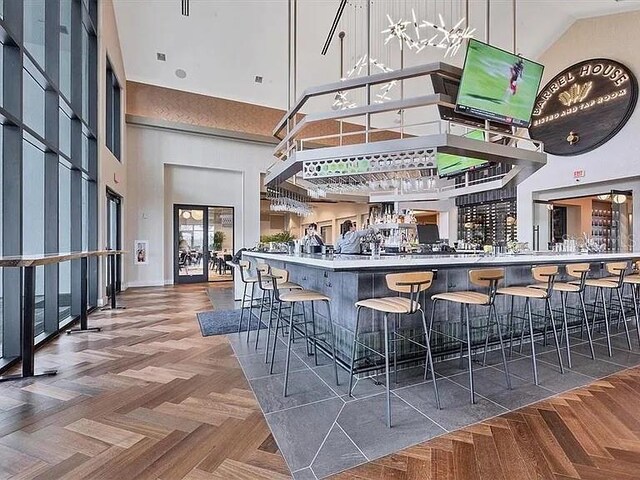 bar featuring a high ceiling and parquet floors