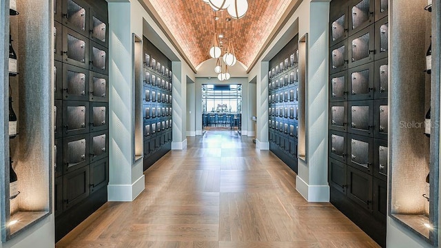 interior space with a mail area, built in shelves, light parquet flooring, and brick ceiling