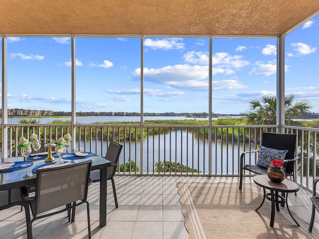 sunroom featuring plenty of natural light and a water view