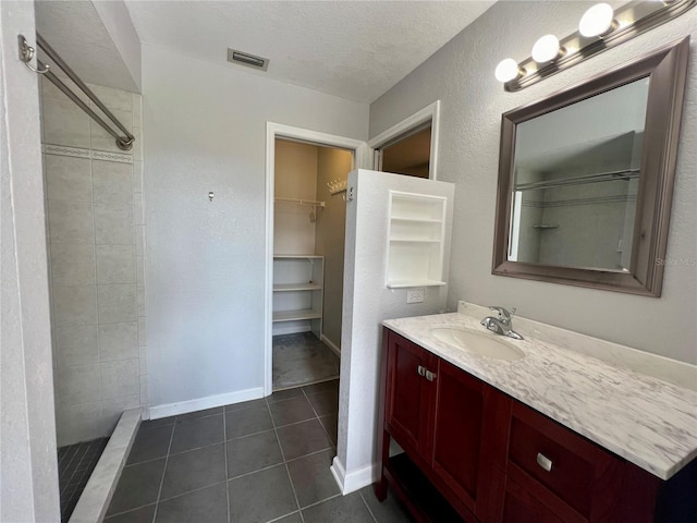 503 Philodendron, Punta Gorda, FL 33955 - bathroom featuring a textured ceiling, tile patterned flooring, visible vents, a shower stall, and a walk in closet