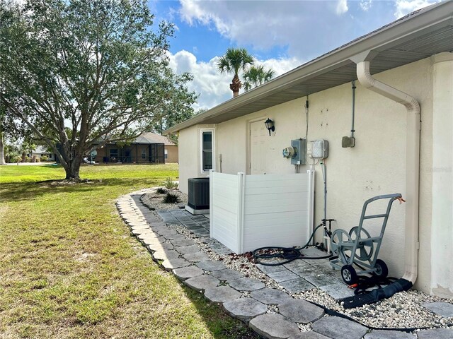 503 Philodendron, Punta Gorda, FL 33955 - view of home's exterior with central AC unit, a lawn, and stucco siding