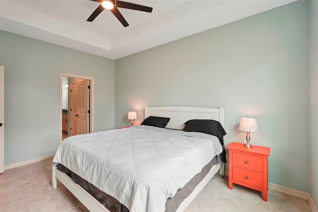 bedroom featuring a tray ceiling, a ceiling fan, and baseboards