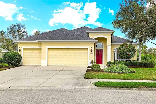 view of front of home featuring a shingled roof, concrete driveway, an attached garage, and stucco siding