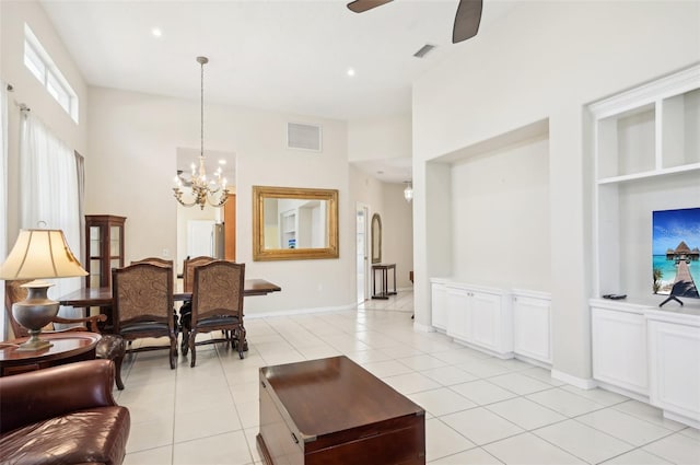 living area featuring ceiling fan with notable chandelier, light tile patterned floors, visible vents, and baseboards