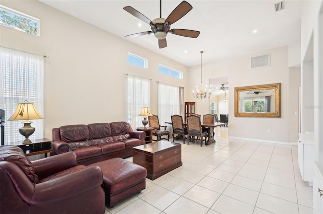 living area featuring ceiling fan with notable chandelier, light tile patterned flooring, visible vents, and baseboards