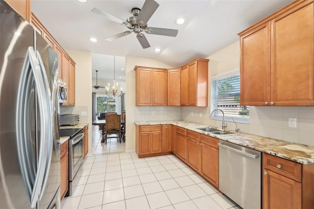 kitchen featuring light tile patterned floors, a sink, appliances with stainless steel finishes, tasteful backsplash, and brown cabinetry