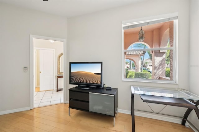 living area with light wood-style flooring and baseboards