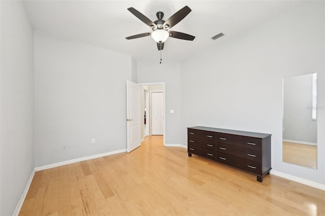 unfurnished bedroom with light wood-style floors, visible vents, ceiling fan, and baseboards