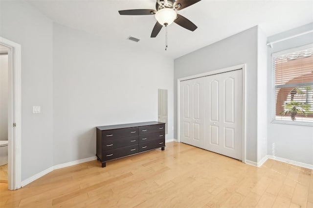 bedroom featuring light wood finished floors, baseboards, visible vents, and a closet