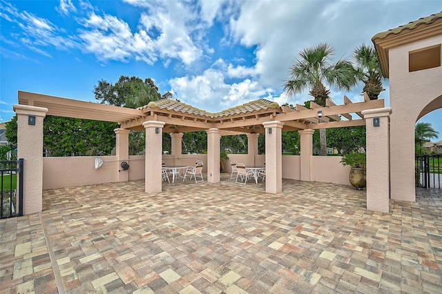 view of patio with outdoor dining space, fence, and a pergola