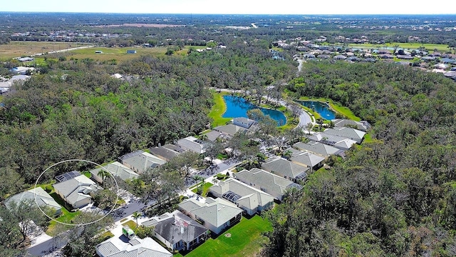 birds eye view of property featuring a residential view, a water view, and a wooded view