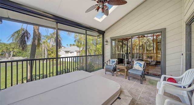 sunroom / solarium featuring lofted ceiling, a ceiling fan, and a healthy amount of sunlight