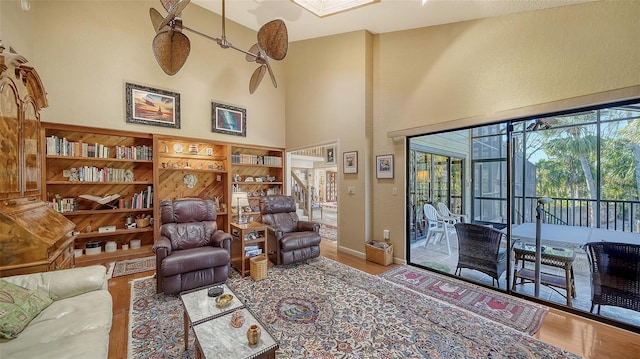 living room with a high ceiling, wood finished floors, and baseboards