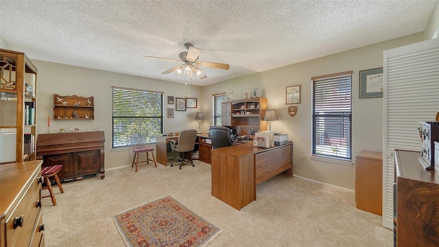 office space with light carpet, ceiling fan, baseboards, and a wealth of natural light