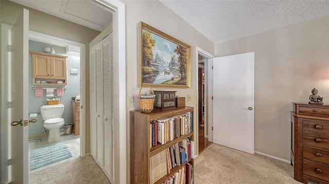 hallway featuring light carpet and a textured ceiling