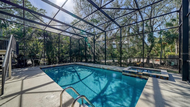 view of swimming pool featuring glass enclosure, a patio area, and a pool with connected hot tub