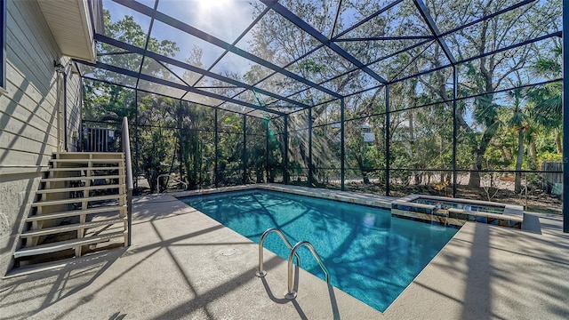 view of swimming pool featuring stairs, glass enclosure, a patio area, and a pool with connected hot tub