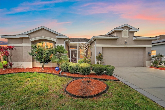 view of front of property featuring concrete driveway, a yard, an attached garage, and stucco siding