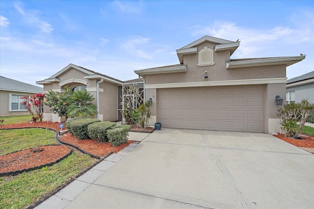 view of front of house with concrete driveway, an attached garage, and stucco siding