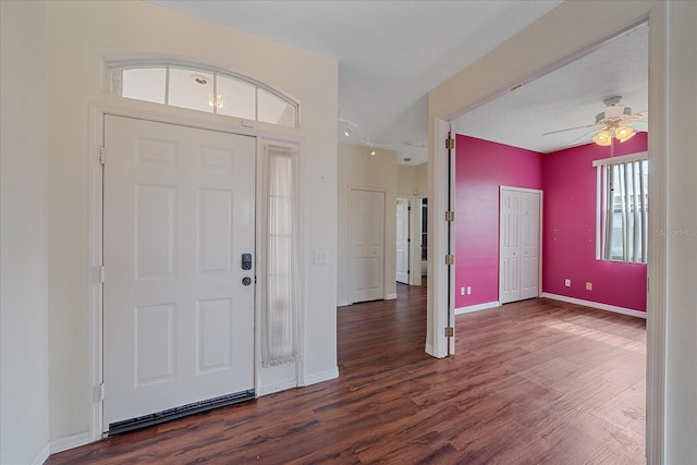 foyer with ceiling fan, baseboards, and dark wood finished floors