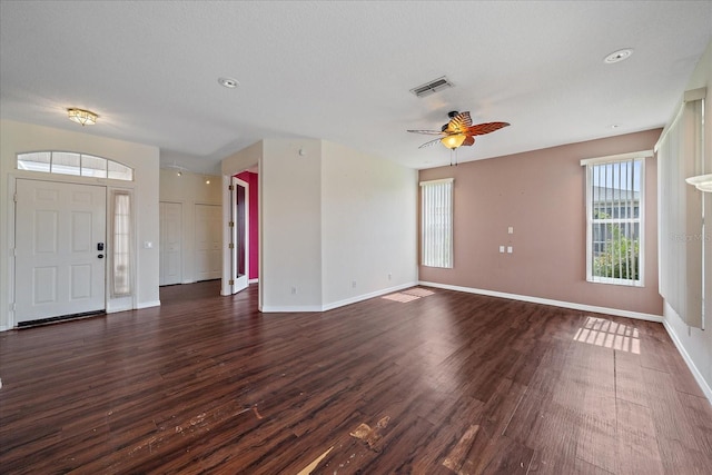 foyer entrance with visible vents, baseboards, ceiling fan, and dark wood-style flooring