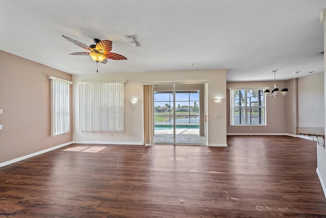 interior space with dark wood-style floors, visible vents, a textured ceiling, and ceiling fan with notable chandelier