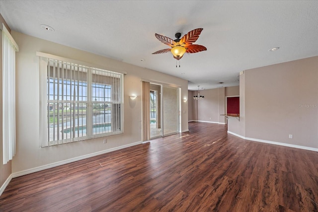 unfurnished living room featuring dark wood-style floors, baseboards, and a ceiling fan