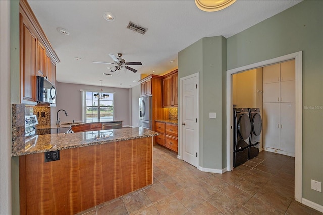 kitchen featuring a peninsula, visible vents, stainless steel refrigerator with ice dispenser, range, and brown cabinetry