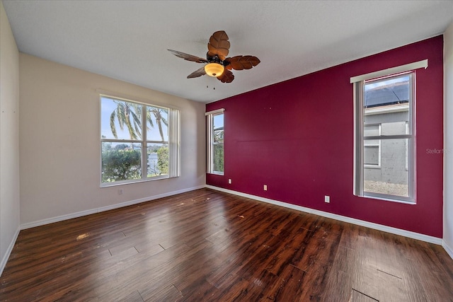 spare room featuring a ceiling fan, baseboards, and wood finished floors