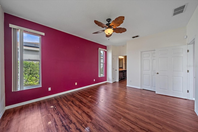 unfurnished bedroom with a ceiling fan, baseboards, visible vents, and wood finished floors