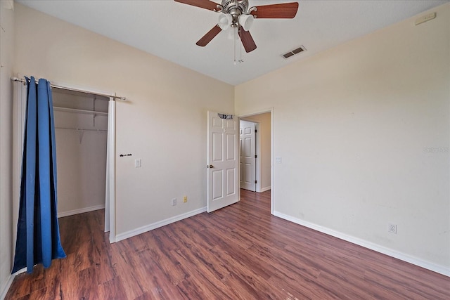 unfurnished bedroom featuring a closet, visible vents, baseboards, and wood finished floors